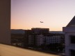 Photo of an airplane flying over Downtown San Jose during the evening